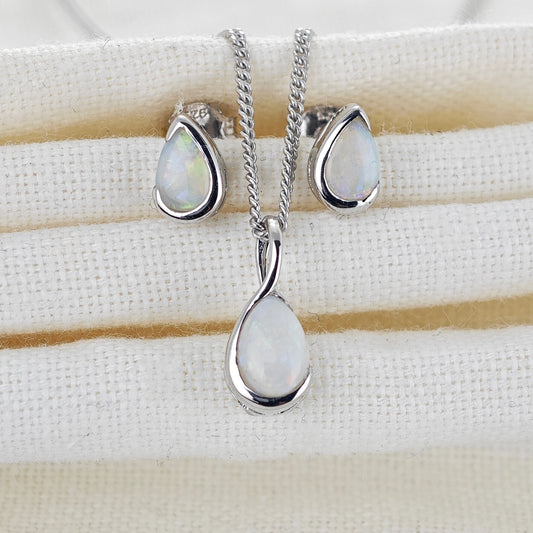 Natural opal pendant and stud set in infinity loop of sterling silver on a fabric jewellery rest